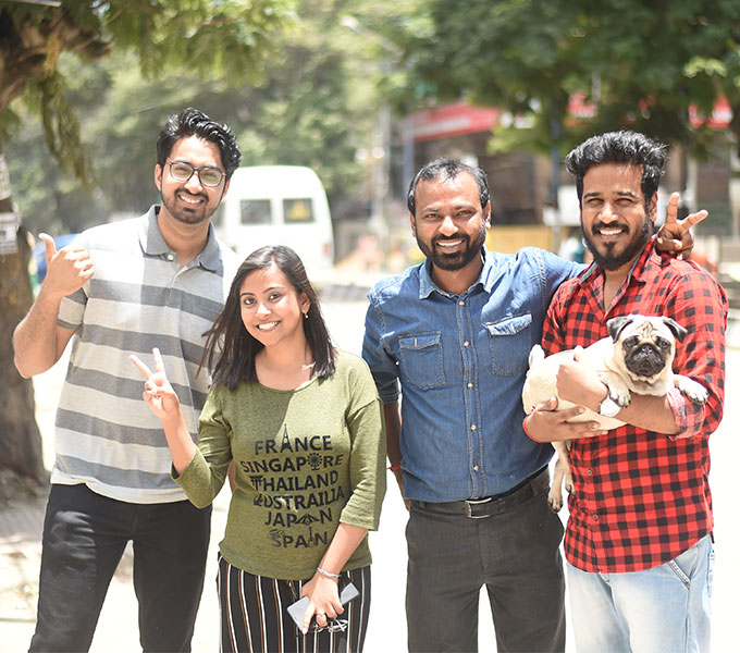 Four team members and the office dog smiling at the camera